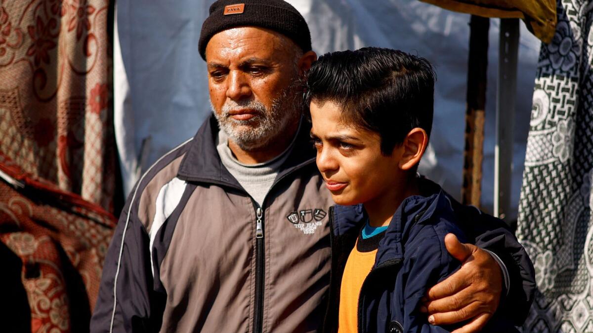 حسام العطار يحتضن والده في مخيم في رفح.  – رويترز