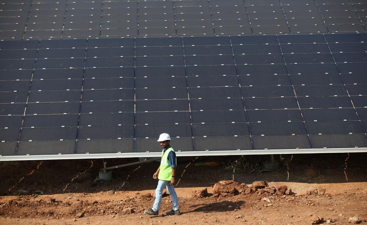 مسؤول يمر أمام الألواح الشمسية المثبتة في مجمع بافاغادا للطاقة الشمسية شمال بنغالور، الهند، 1 مارس 2018. — ملف AP