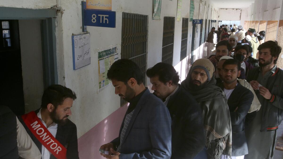 أشخاص يقفون في طابور وهم ينتظرون دورهم للإدلاء بأصواتهم خارج مركز اقتراع في جمرود، في منطقة خيبر.  — ا ف ب
