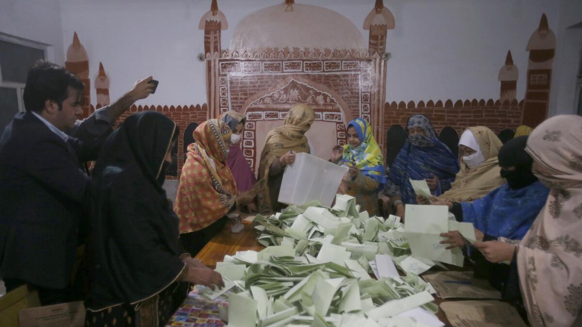 أعضاء طاقم الاقتراع يقومون بإحصاء الأصوات بعد إغلاق مراكز الاقتراع لإجراء الانتخابات البرلمانية في بيشاور.  — ا ف ب