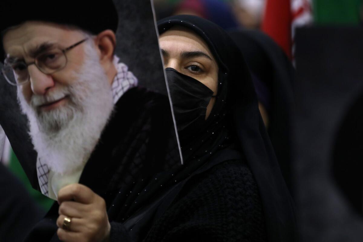 امرأة إيرانية تحمل ملصقًا للمرشد الأعلى آية الله علي خامنئي خلال تجمع انتخابي قبل الأول من مارس. – أسوشيتد برس