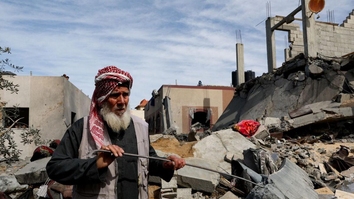 فلسطيني يقف في موقع غارة إسرائيلية على منزل في رفح.  – رويترز