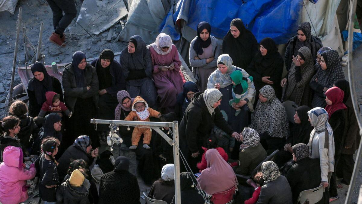 فلسطينيون يجلسون وسط الخيام والملاجئ المؤقتة التي دمرتها الغارات الإسرائيلية في دير البلح وسط قطاع غزة.  – وكالة فرانس برس