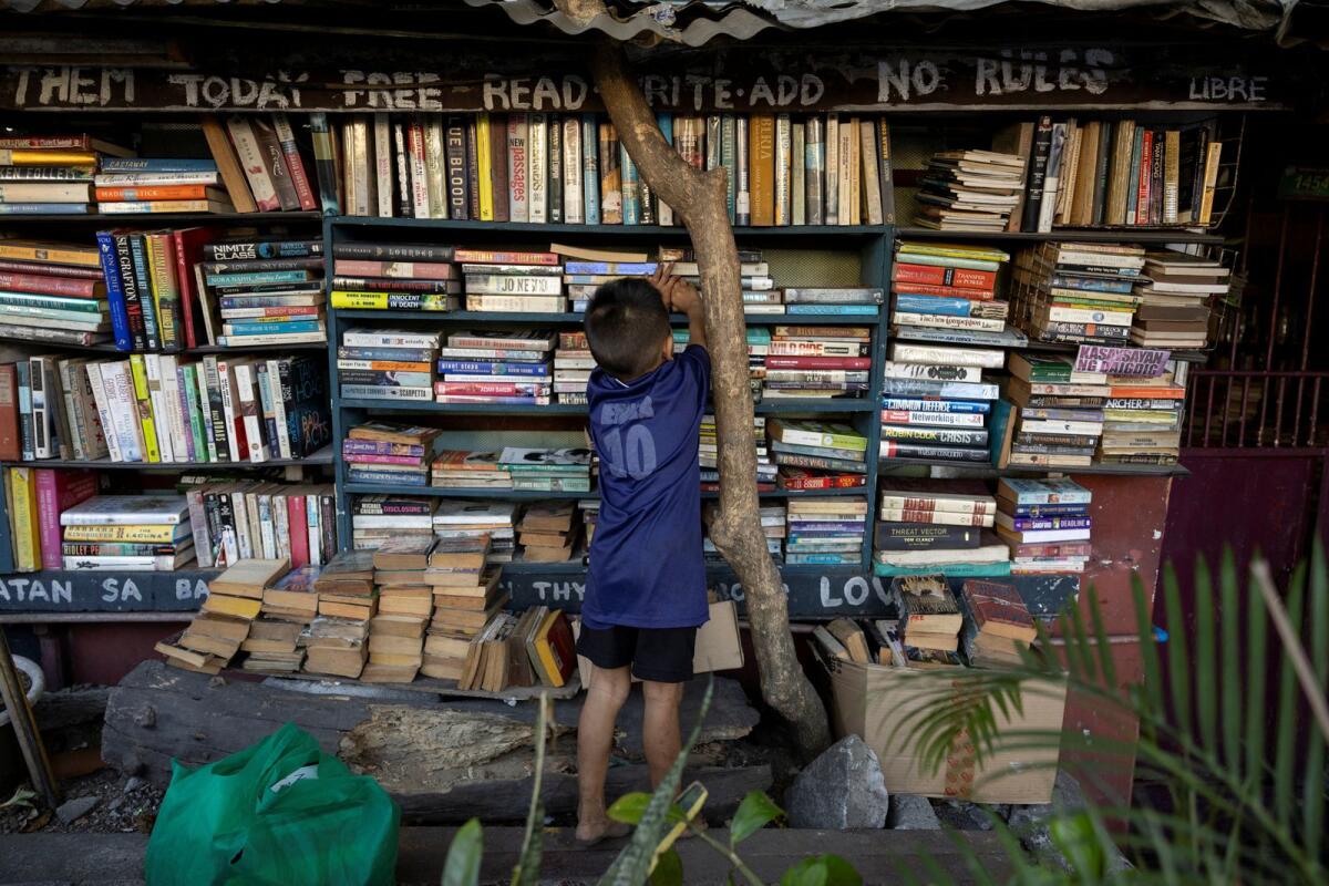 صبي يختار كتابًا في مكتبة هيرناندو جوانلاو العامة في ماكاتي، مترو مانيلا، الفلبين، في 7 فبراير 2024. – رويترز