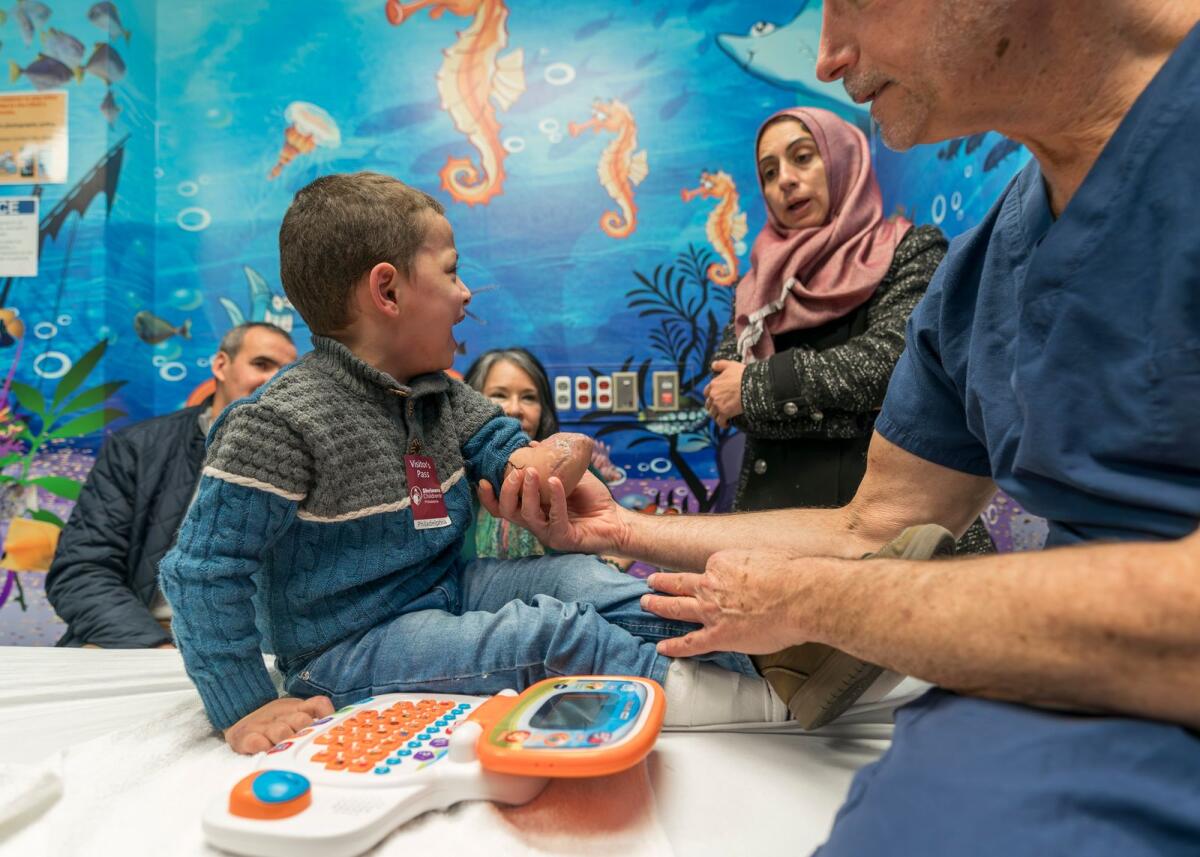 عمر أبو كويك البالغ من العمر أربع سنوات يبكي بينما يقوم جراح العظام الدكتور سكوت كوزين بفحص ذراعه في مستشفى شرينرز للأطفال، في 18 يناير 2024، في فيلادلفيا.  — ا ف ب