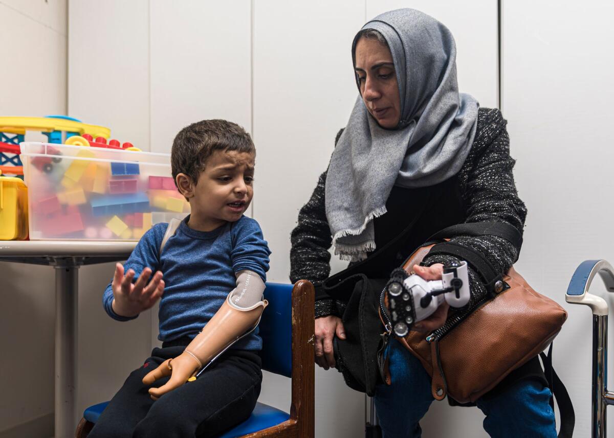 يعبر عمر أبو كويك، البالغ من العمر أربع سنوات، عن إحباطه من استخدام ذراعه الاصطناعية الجديدة مع عمته، مها أبو كويك، خلال جلسة العلاج المهني في مستشفى شرينرز للأطفال في 28 فبراير 2024، في فيلادلفيا.  — ا ف ب