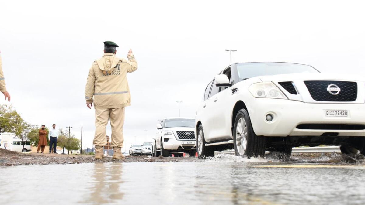ضابط شرطة يتحكم في حركة المرور في شارع تغمره المياه في دبي.