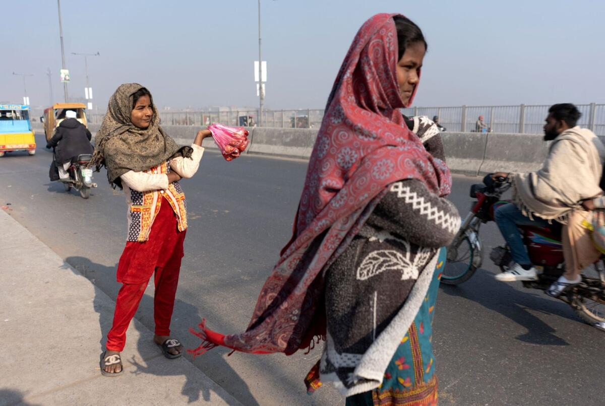 فتاة تنتظر العملاء أثناء بيع اللحوم لإطعام الطيور في لاهور.  – رويترز