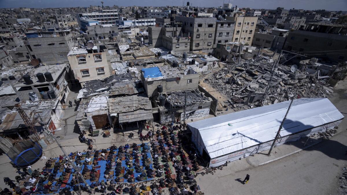 فلسطينيون يؤدون صلاة الجمعة الأولى من شهر رمضان المبارك بالقرب من أنقاض مسجد دمرته الغارات الجوية الإسرائيلية في رفح.  — ا ف ب
