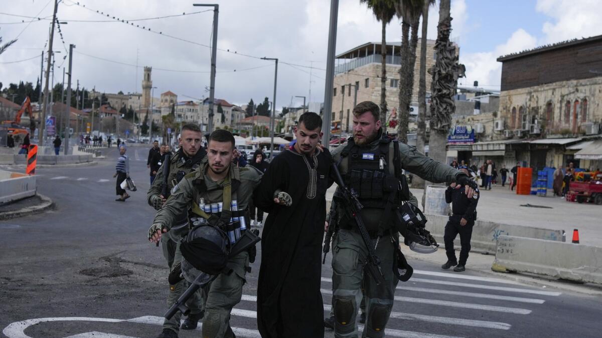 قوات الأمن الإسرائيلية تعتقل رجلاً فلسطينياً خارج البلدة القديمة في القدس.  — ا ف ب