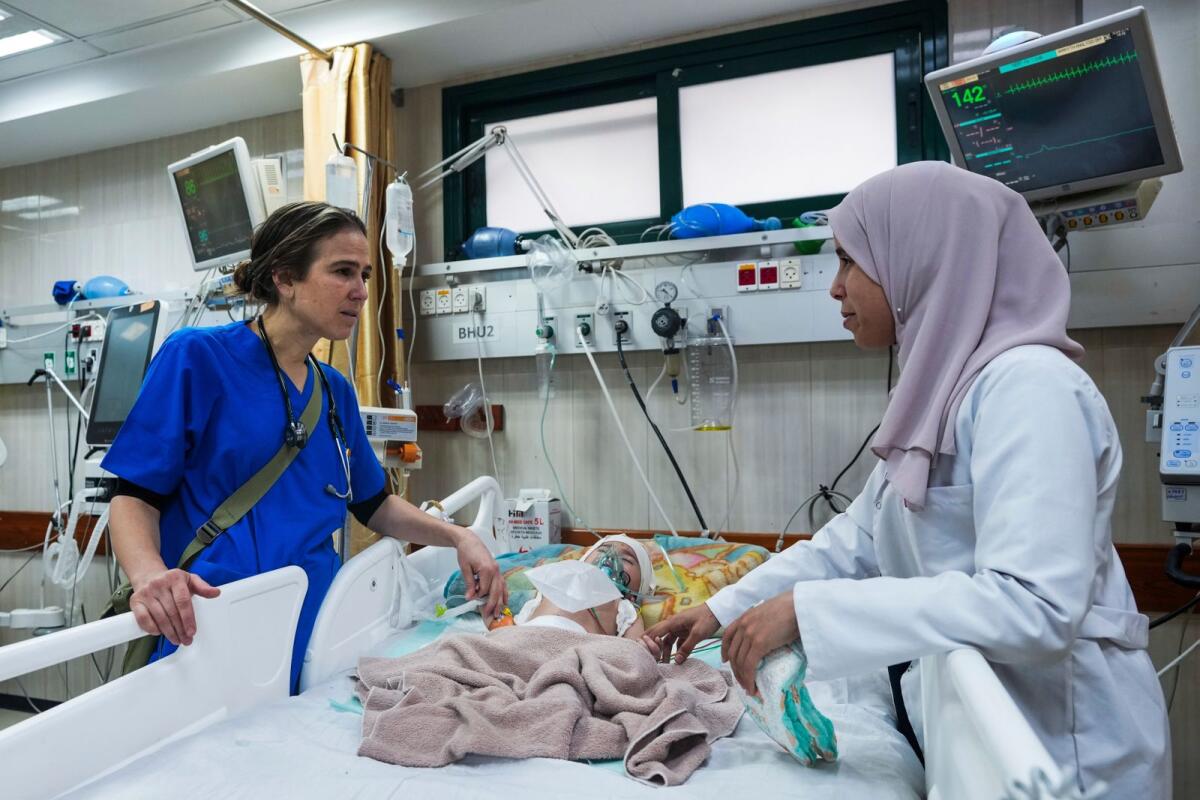 طبيبة الأطفال تانيا الحاج حسن تفحص الأطفال الجرحى في مستشفى شهداء الأقصى في دير البلح، وسط غزة، في 16 مارس، 2024. — AP