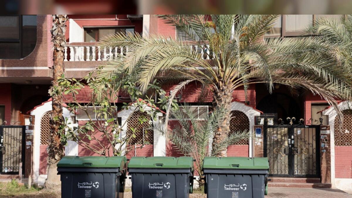 حاويات إعادة التدوير الخضراء موضوعة في منطقة سكنية في أبوظبي.