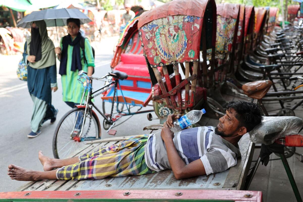 رجل يستريح على عربة أثناء موجة الحر في دكا، بنغلاديش.  – رويترز