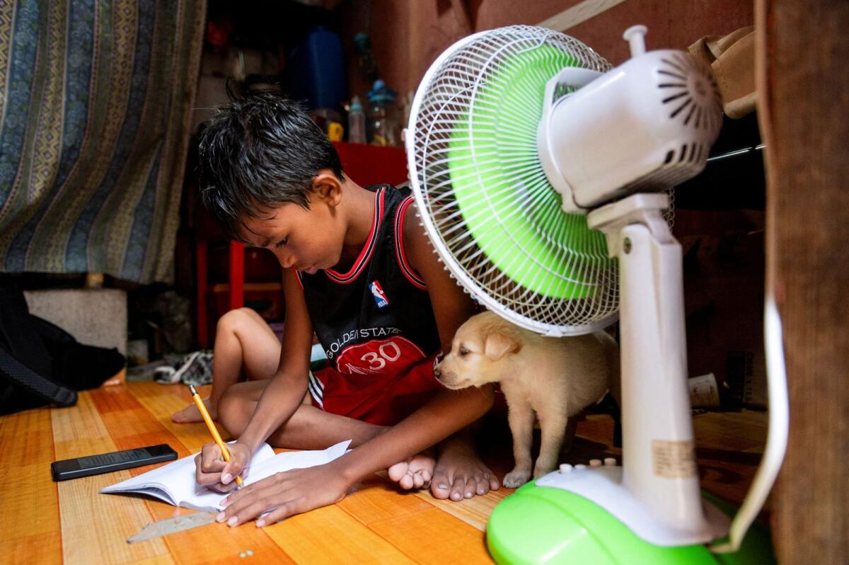 يجيب أحد الطلاب على وحدة التعلم الخاصة به بعد تعليق الفصول الدراسية الشخصية، داخل منزله في مانيلا، الفلبين، في 26 أبريل 2024. — رويترز