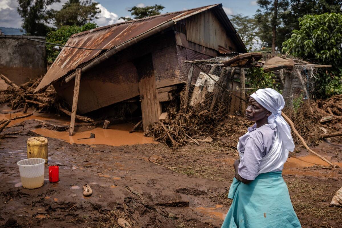 امرأة تقف لتقييم الأضرار أمام منزلها المدمر في منطقة تضررت بشدة من الأمطار الغزيرة والفيضانات في قرية كاموتشيري، بالقرب من ماي ماهيو، يوم الاثنين.  – وكالة فرانس برس