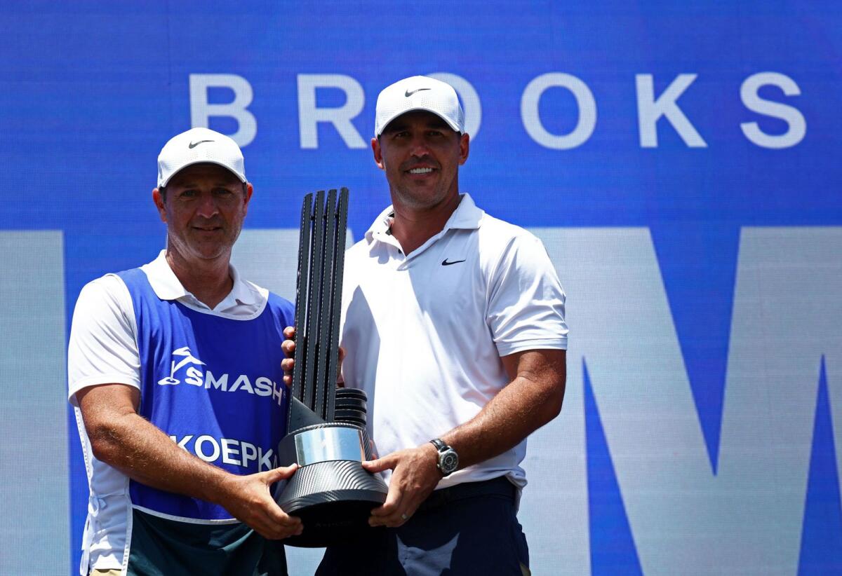 يحتفل Brooks Koepka من Smash GC مع حامله والكأس بعد فوزه بسباق LIV Golf Singapore.  - رويترز