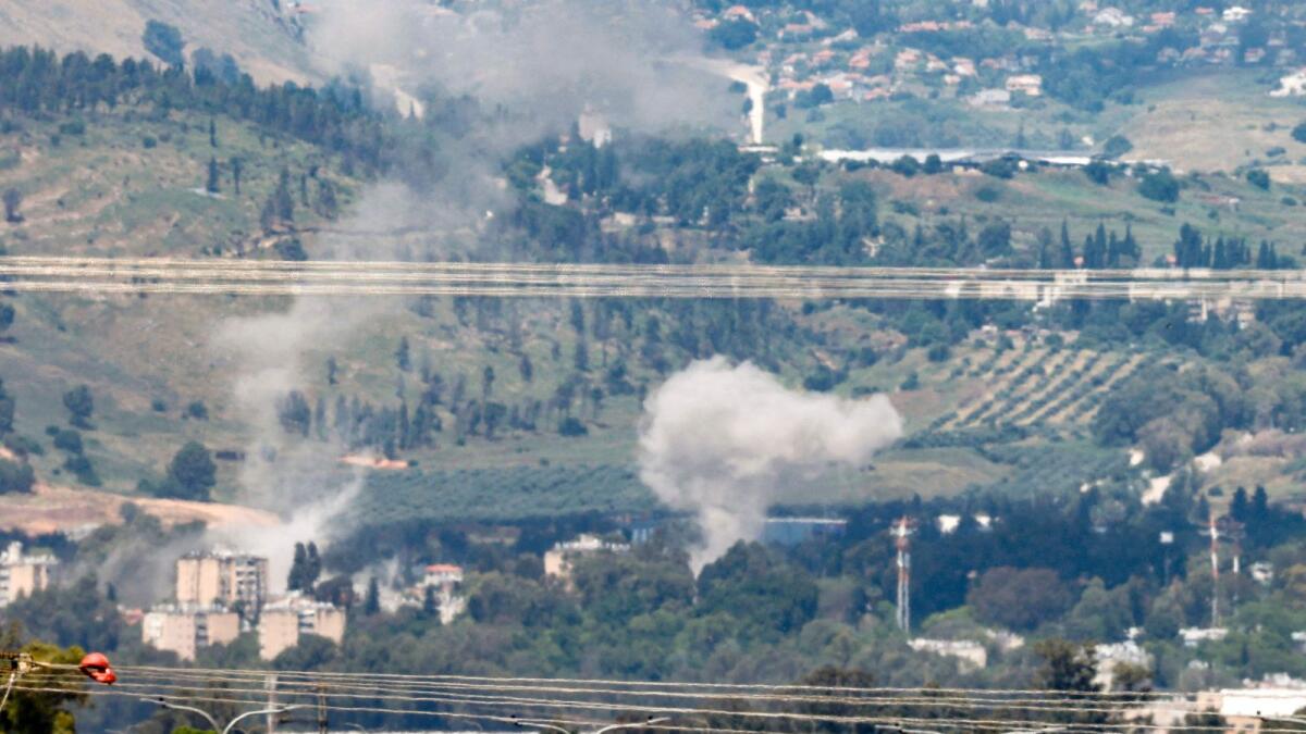 دخان يتصاعد في مدينة كريات شمونة الحدودية شمال إسرائيل بعد إطلاق صواريخ من جنوب لبنان.  – وكالة فرانس برس